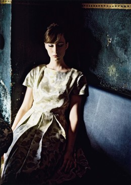Sibylle Bergemann Modefotografie Lily Berlin 2009, in blau türkisen Farben sitzt eine Frau mit geschlossenen Augen in der Ecke einer Cafebank